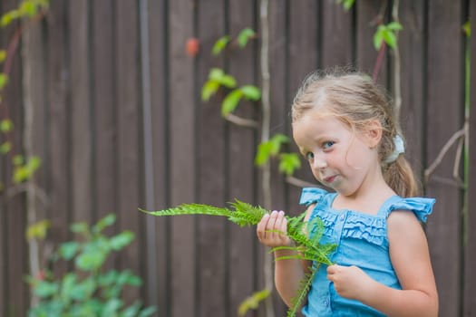 child girl dancing in the field park. happy childhood a family friendship concept. girl kid whirls in a blue dress in grass in the summer park. daughter in dancing whirls in the summer in nature sun