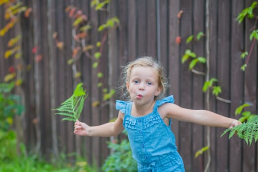 child girl dancing in the field park. happy childhood a family friendship concept. girl kid whirls in a blue dress in grass in the summer park. daughter in dancing whirls in the summer in nature sun