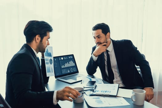 Busy analyst team discussing financial data on digital dashboard, analyzing chart and graph using data science software display on a laptop screen. Business intelligence and Fintech. Fervent