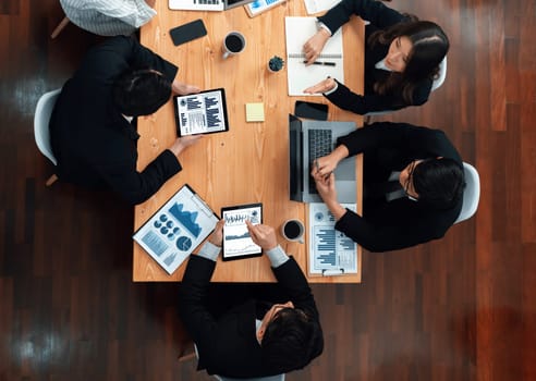 Top-view business team of financial data analysis meeting with business intelligence, report paper and dashboard on laptop for marketing strategy. Business people working together in office of harmony