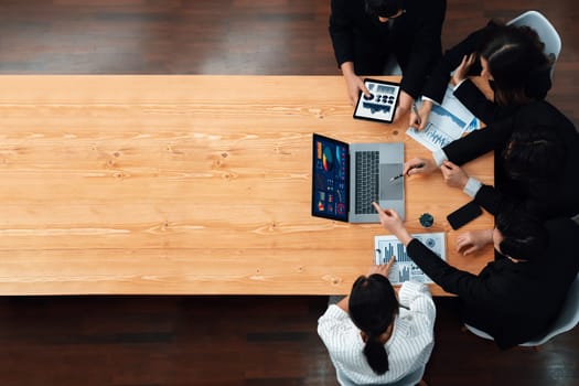 Top-view business team of financial data analysis meeting with business intelligence, report paper and dashboard on laptop for marketing strategy. Business people working together in office of harmony