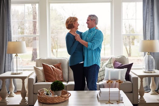 In the recipe for a happy marriage, romance is key. a happy mature couple dancing together in their living room at home