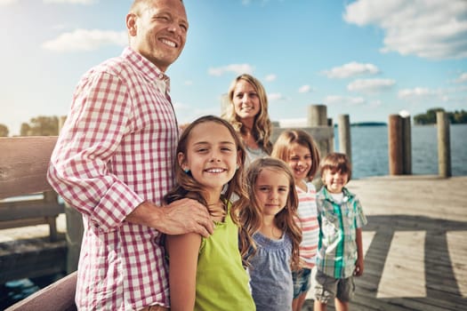 Family is not an important thing, its everything. a young family on a pier while out by the lake