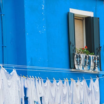 The characteristic colored houses of Burano (Venice) reflected on the water of a canal