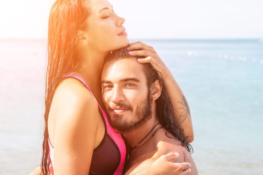 Close up shot of beautiful young caucasian woman with black hair and freckles looking at camera and smiling. Cute woman portrait in a pink bikini posing on a volcanic rock high above the sea