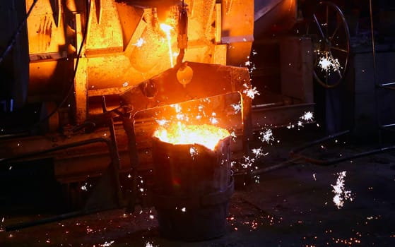 Casting steel at a steel plant. Molten metal was poured from the ladle. Metallurgical production, heavy industry, sewer manhole smelting.