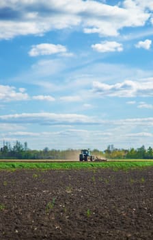 The tractor plows the soil in the field. Selective focus. Nature.