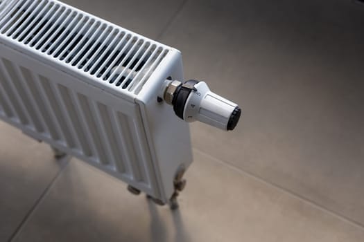 Close-up of white central heating floor radiator with a power regulator in the maximum position.