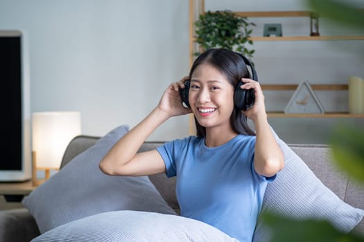 Beautiful young smart teenager woman with headphones relaxing on the bed sofa at home, Happy young teenager Asian listen relaxing song at home. High quality photo