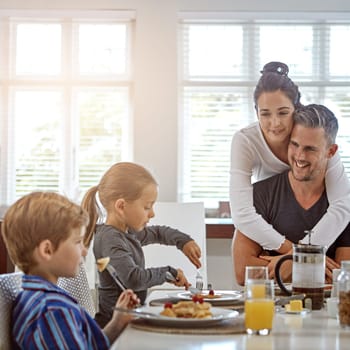 Refuelling their bodies for the day ahead. a family having breakfast together