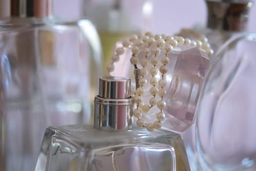 pearl necklace resting on perfume bottles