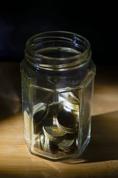 glass jar full of coins for savings concept