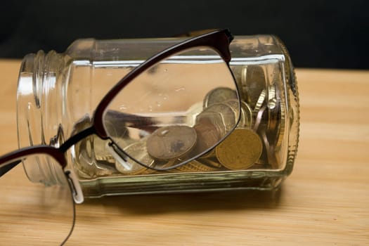 glass jar full of coins for savings concept