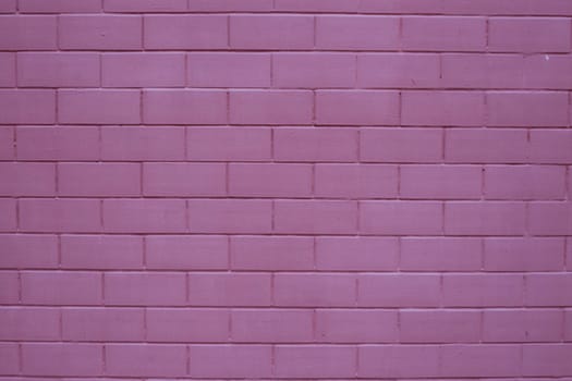 Painted brick wall in pink purple paint texture stone background