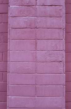 The brick wall of the building is painted red.