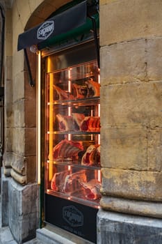 Bilbao, Basque country, Spain - 12.06.2022: Glass window showcase of the Sugarra store, with samples and meat cuts