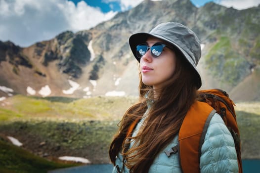 Happy, woman and female student with a backpack outdoors in the mountains resting during the holidays. freedom concept. Portrait of a girl in sunglasses during a walk.