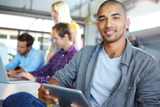 Bringing bright optimism to the workplace. Portrait of a designer using a digital tablet with colleagues in the background