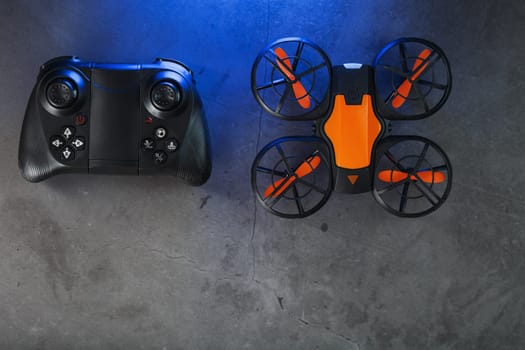 Quadcopter drone with joystick control and blue neon backlight, on a dark textured background