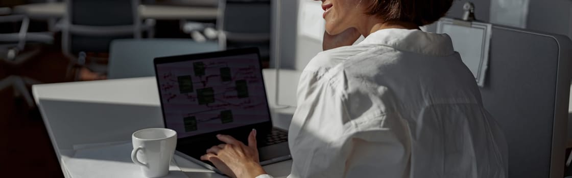 Attractive european business woman working laptop while sitting in cozy cafe. Blurred background