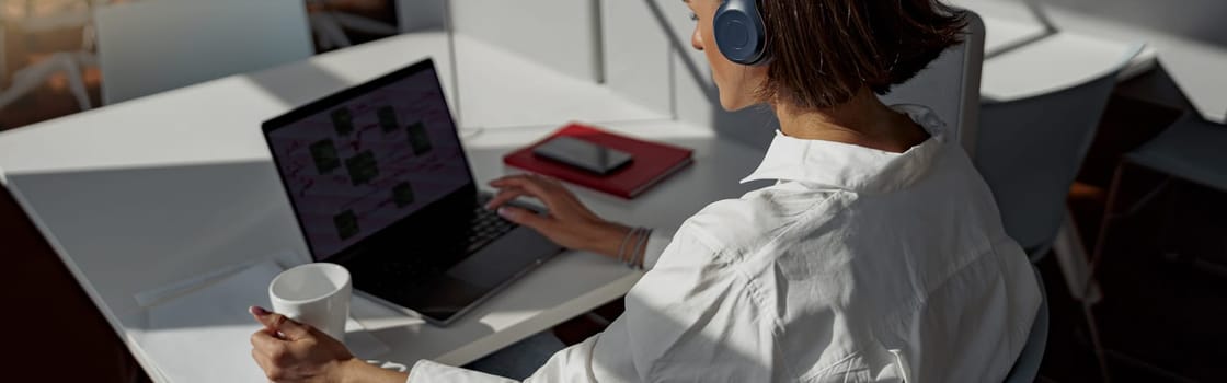 Attractive european business woman working laptop while sitting in cozy cafe. Blurred background