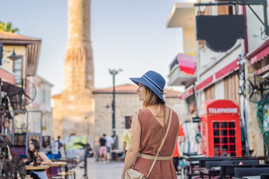 Happy woman tourist on background of old street of Antalya. female tourist traveler discover interesting places and popular attractions and walks in the old city Kalechi of Antalya, Turkey. Turkiye.