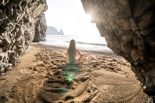 Middle aged well looking woman with black hair doing Pilates with the ring on the yoga mat near the sea on the pebble beach. Female fitness yoga concept. Healthy lifestyle, harmony and meditation.