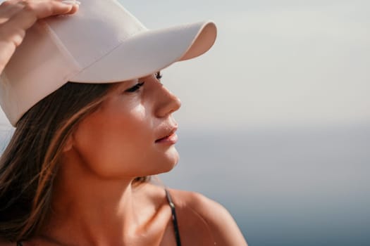 Woman travel sea. Happy tourist taking picture outdoors for memories. Woman traveler looks at the edge of the cliff on the sea bay of mountains, sharing travel adventure journey.