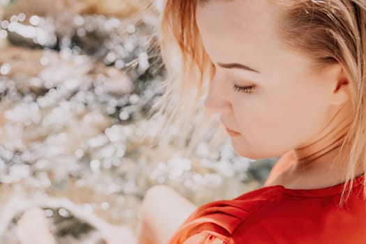 Woman travel sea. Young Happy woman in a long red dress posing on a beach near the sea on background of volcanic rocks, like in Iceland, sharing travel adventure journey