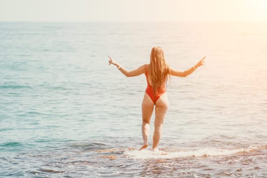 Woman sea yoga. Back view of free calm happy satisfied woman with long hair standing on top rock with yoga position against of sky by the sea. Healthy lifestyle outdoors in nature, fitness concept.