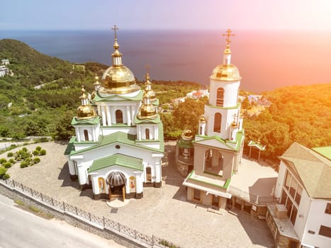 Christian church on a background of mountains. Temple of the Holy Archangel Michael in Oreanda. The southern coast of Crimea. Located on a rocky cliff and is surrounded by beautiful vegetation