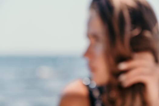 Woman travel sea. Young Happy woman in a long red dress posing on a beach near the sea on background of volcanic rocks, like in Iceland, sharing travel adventure journey