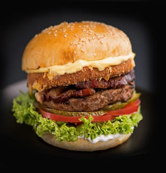 Cheeseburger with beef,tomato, lettuce and onion on wooden table. Copy space