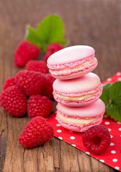 Pink raspberry macaron cookies on dark wooden boards