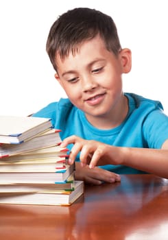 Child and books. The boy reads and plays with books. A preschooler is learning to read. Portrait of a boy on a white background