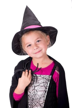 A beautiful girl in a witch costume, in a hat, with a spider in her hands on a light background, copy space. The witch waves her magic wand. Happy Halloween.