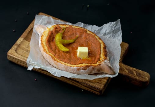 Traditional Georgian pastry - Adjarian khachapuri with cheese and vegetables Khachapuri on a wooden background in a rustic style. Khachapuri with ingredients.