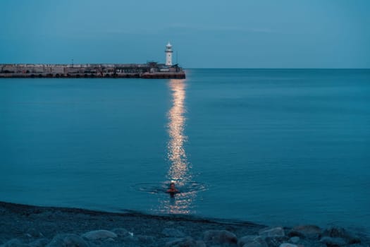 Woman The full moon rises to the lighthouse, the lunar path along the sea leads to the woman