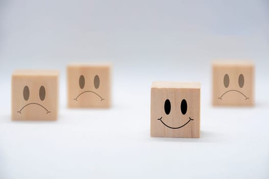 Happy and sad emotion faces on wooden cubes. Customer satisfaction and evaluation concept