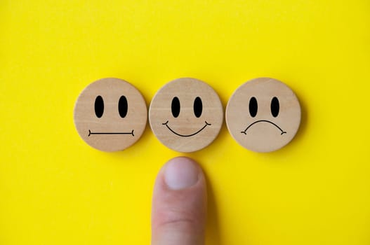 Neutral, happy and sad emotion faces on wooden cubes. Customer satisfaction and evaluation concept