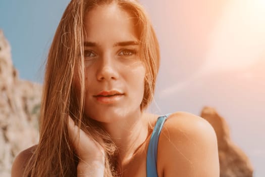 Woman travel sea. Young Happy woman in a long red dress posing on a beach near the sea on background of volcanic rocks, like in Iceland, sharing travel adventure journey