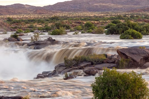 Sunrise view of falls in the Orange River directly above the main Augrabies waterfall. The river is in flood