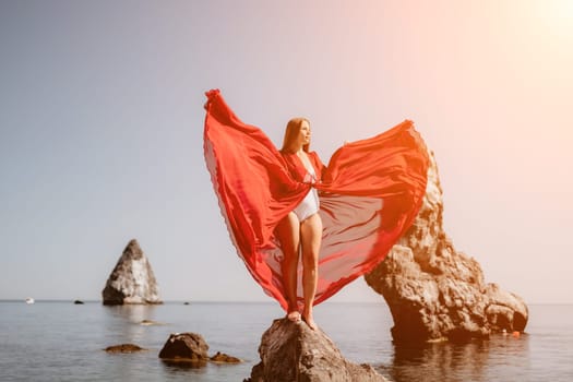 Woman travel sea. Happy tourist taking picture outdoors for memories. Woman traveler looks at the edge of the cliff on the sea bay of mountains, sharing travel adventure journey.