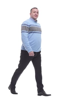 side view. a serious man in a sweater walks forward. isolated on a white background
