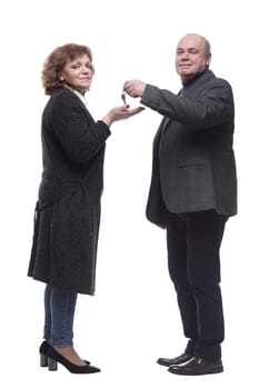 side view. realtor handing keys to a happy woman. isolated on a white background