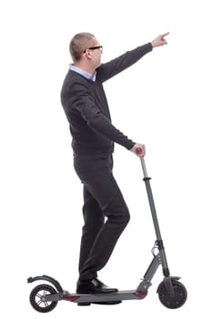 Full length portrait of an young businessman riding a scooter and pointed at camera isolated on white background