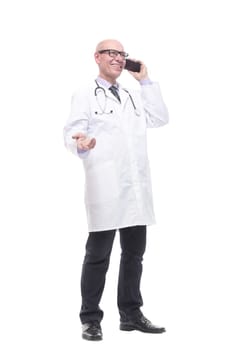 in full growth. smiling doctor with a smartphone. isolated on a white background.
