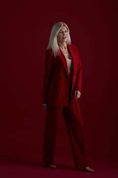 Portrait of a blonde woman in red dress on a red background