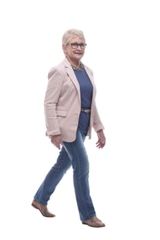 in full growth. confident senior woman goes forward . isolated on a white background