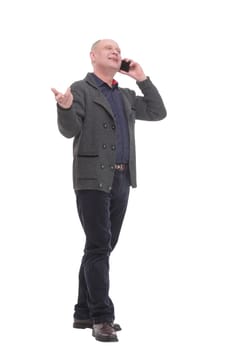 in full growth. smiling mature man with a smartphone .isolated on a white background.